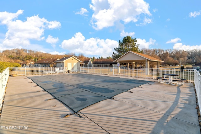 view of swimming pool featuring a gazebo, a shed, and a patio area