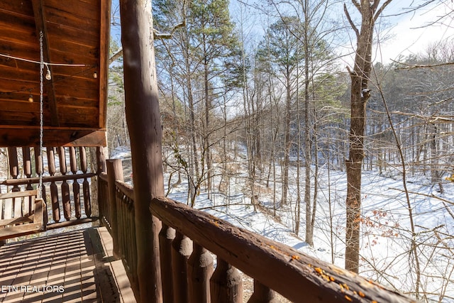 view of snow covered back of property