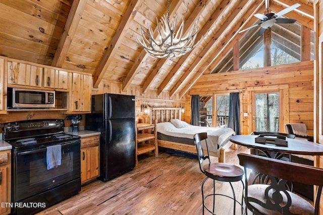 kitchen with wood walls, wooden ceiling, beam ceiling, light hardwood / wood-style floors, and black appliances