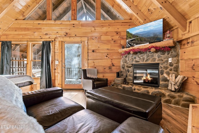 living room featuring wood ceiling, a fireplace, beamed ceiling, and wood walls