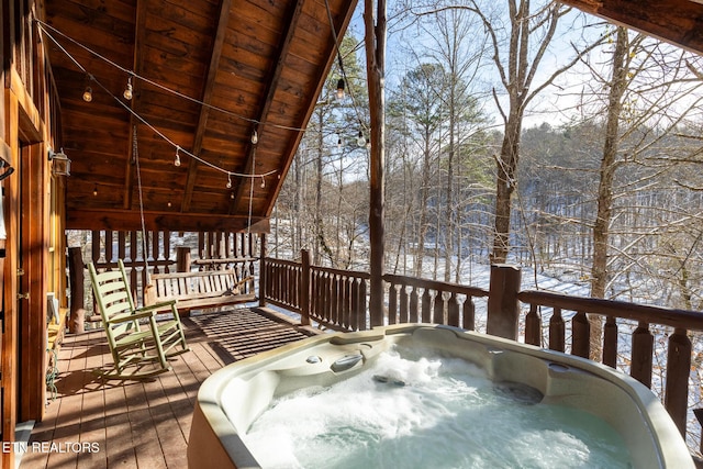 snow covered deck featuring a hot tub