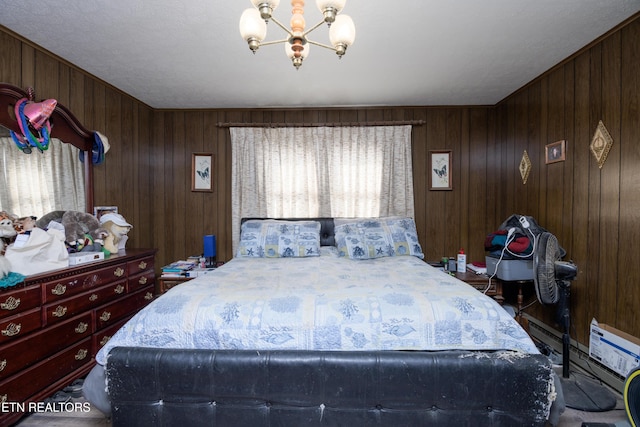 bedroom featuring multiple windows, an inviting chandelier, and wood walls