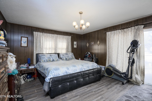 bedroom with wood-type flooring, multiple windows, and a notable chandelier