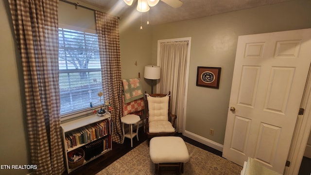 sitting room with ceiling fan and dark hardwood / wood-style flooring