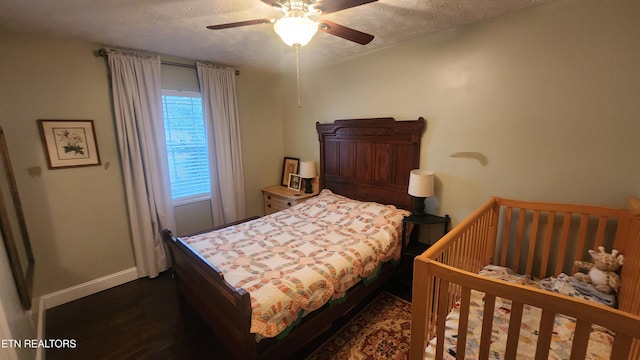 bedroom featuring ceiling fan, dark hardwood / wood-style floors, and a textured ceiling