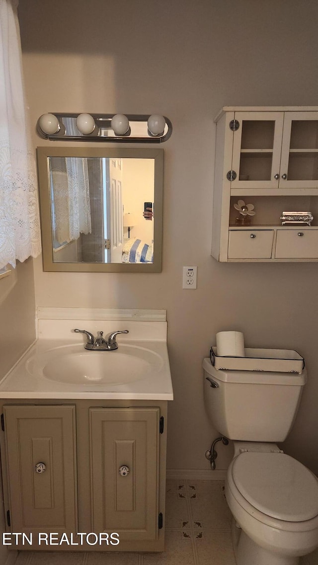 bathroom with tile patterned flooring, vanity, and toilet