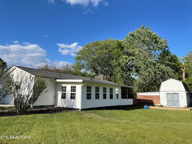 back of house featuring a lawn and a storage unit