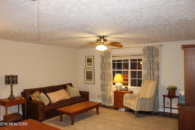 living room featuring ceiling fan and a textured ceiling