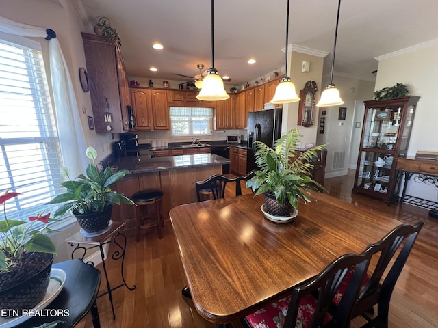 dining space with ornamental molding, dark hardwood / wood-style floors, and sink