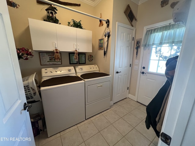 clothes washing area with cabinets, independent washer and dryer, crown molding, and light tile patterned floors