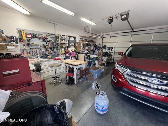 garage with a garage door opener and a workshop area