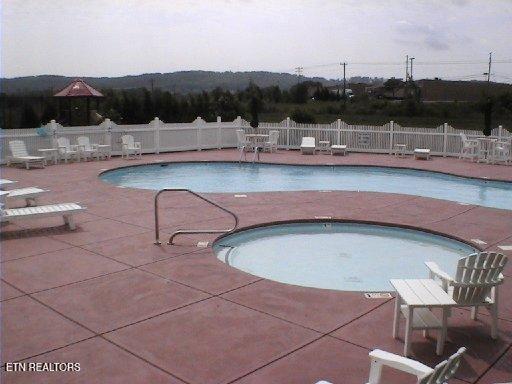 view of pool featuring a hot tub and a patio area