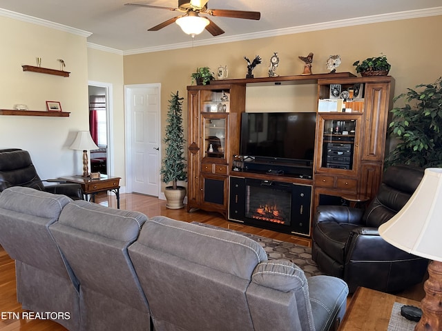 living room with wood-type flooring, ceiling fan, and crown molding