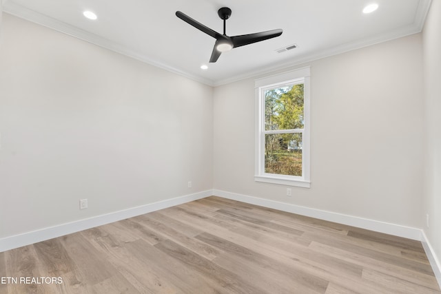 empty room with ornamental molding, visible vents, light wood-style flooring, and baseboards