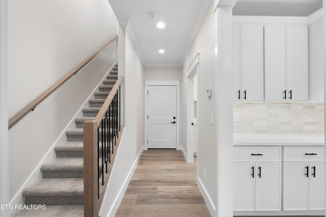 interior space with baseboards, recessed lighting, wood finished floors, and crown molding