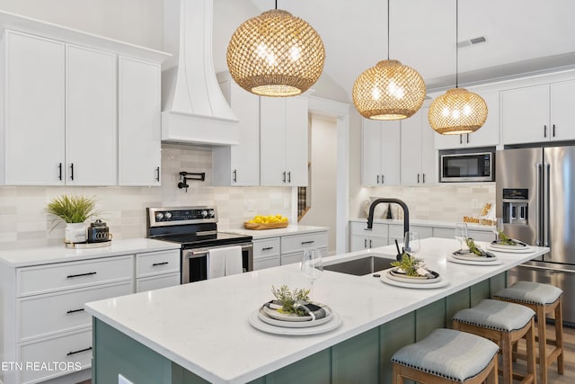 kitchen featuring white cabinetry, appliances with stainless steel finishes, and pendant lighting