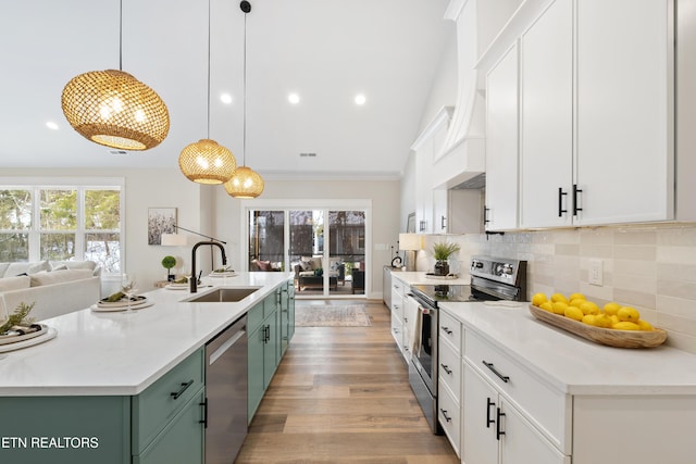 kitchen with hanging light fixtures, appliances with stainless steel finishes, white cabinetry, and green cabinetry