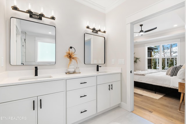 ensuite bathroom featuring crown molding, double vanity, a sink, ensuite bath, and wood finished floors