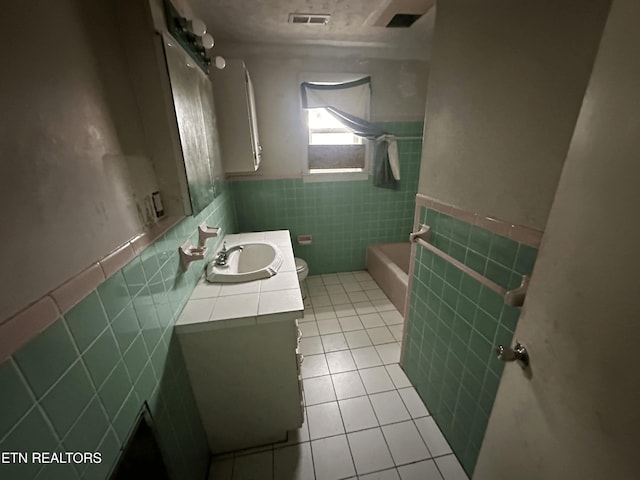 full bathroom with tile walls, vanity, tile patterned floors, shower / bathtub combination, and toilet