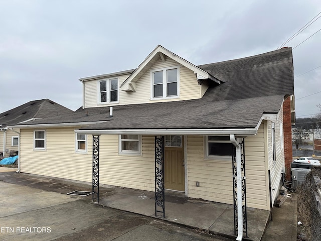 view of front of property featuring a patio and a shingled roof