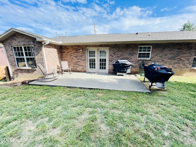 rear view of property with a yard and a patio area