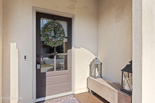 entrance to property featuring stucco siding