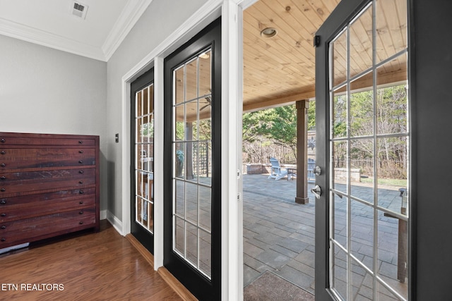 doorway to outside with wood finished floors, visible vents, baseboards, french doors, and crown molding