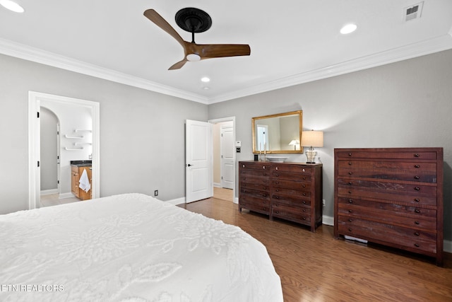 bedroom featuring dark wood-type flooring, ceiling fan, crown molding, and ensuite bath