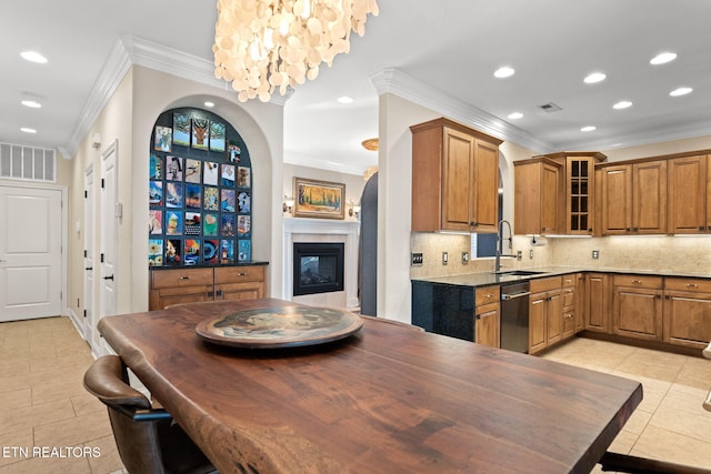 kitchen featuring light tile patterned floors, dishwashing machine, sink, and backsplash