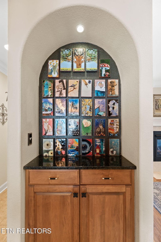 interior space featuring a glass covered fireplace and crown molding