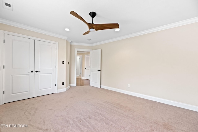 unfurnished bedroom featuring light carpet, crown molding, a closet, and ceiling fan