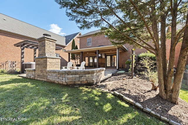 rear view of house featuring a lawn, a patio, french doors, brick siding, and ceiling fan