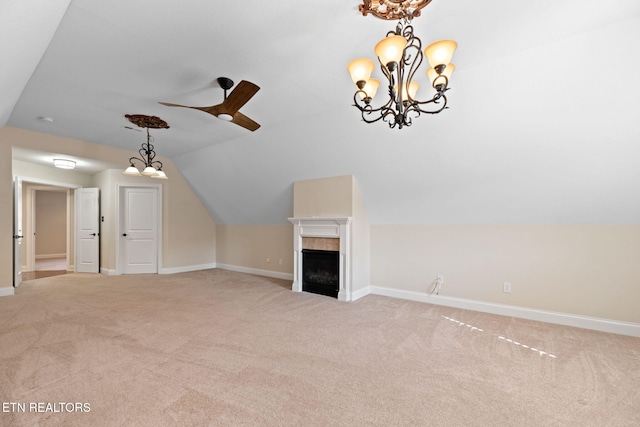 unfurnished living room with ceiling fan with notable chandelier, lofted ceiling, light colored carpet, and a fireplace