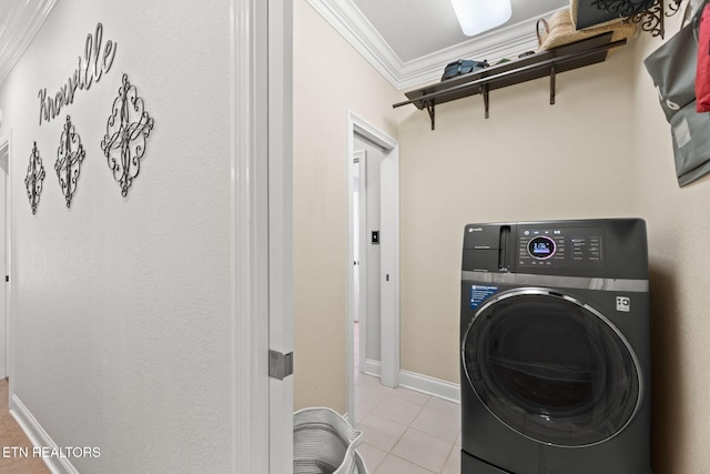 laundry area with baseboards, ornamental molding, light tile patterned floors, laundry area, and washer / clothes dryer