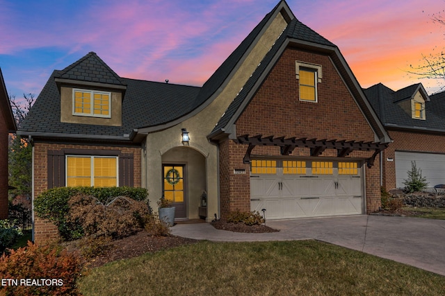 view of front facade featuring a yard, brick siding, and driveway