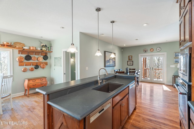 kitchen with a kitchen island with sink, sink, stainless steel appliances, and a healthy amount of sunlight