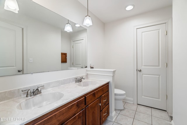 bathroom with tile patterned flooring, vanity, and toilet