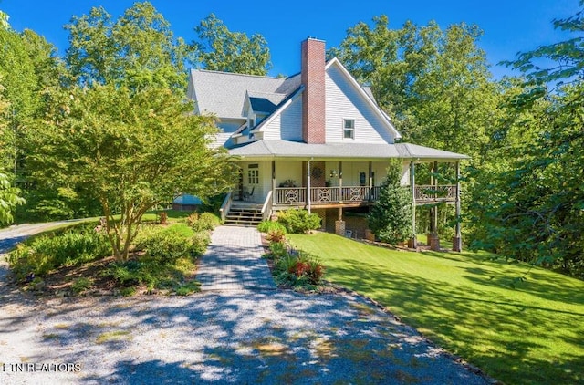 country-style home featuring a porch, a front yard, and a chimney