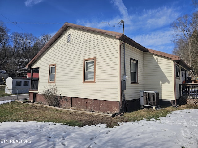 view of snow covered exterior with central AC