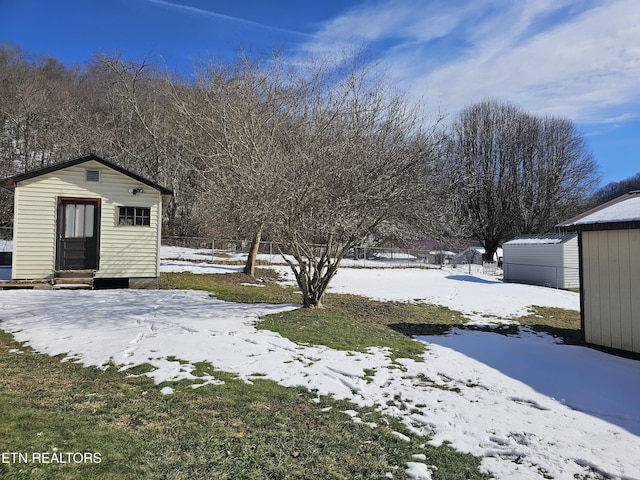 yard covered in snow featuring a shed