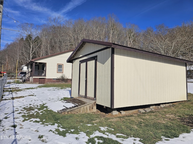 view of snowy exterior featuring a storage unit