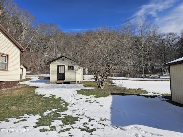 yard layered in snow with a storage shed