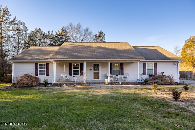 ranch-style house featuring a front yard and covered porch