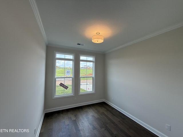 spare room featuring baseboards, ornamental molding, and visible vents