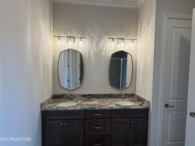 full bath with double vanity, a sink, and ornamental molding