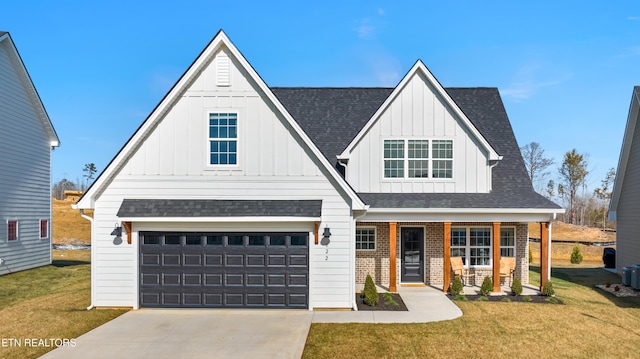 view of front of house with a garage, a front yard, and a porch