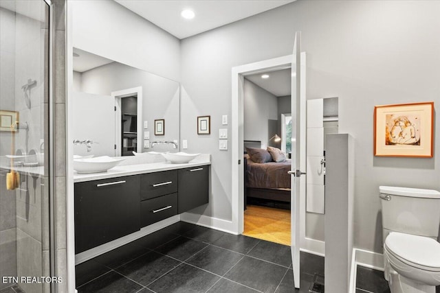 bathroom with vanity, a shower with shower door, tile patterned floors, and toilet