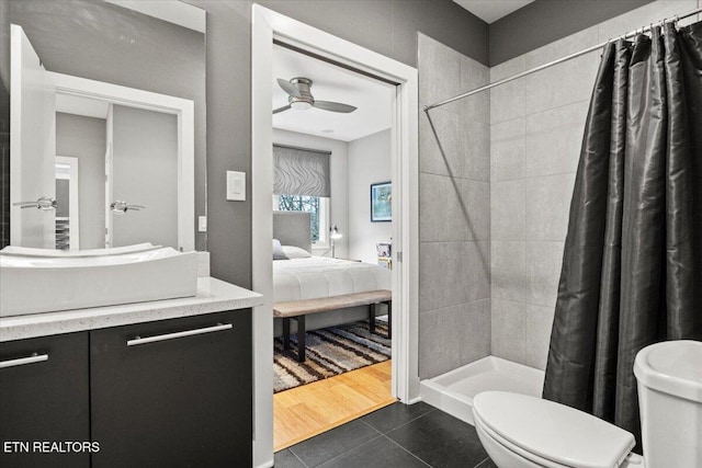 bathroom featuring ceiling fan, vanity, a shower with curtain, tile patterned floors, and toilet