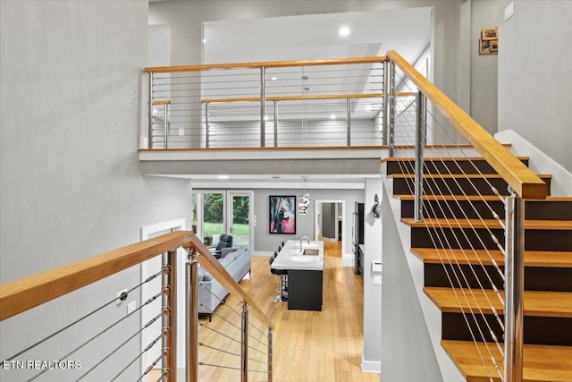 staircase featuring hardwood / wood-style flooring and a high ceiling