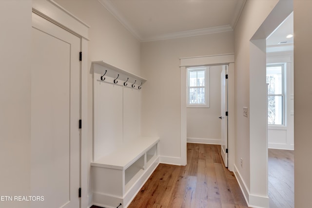 mudroom with ornamental molding and light hardwood / wood-style flooring